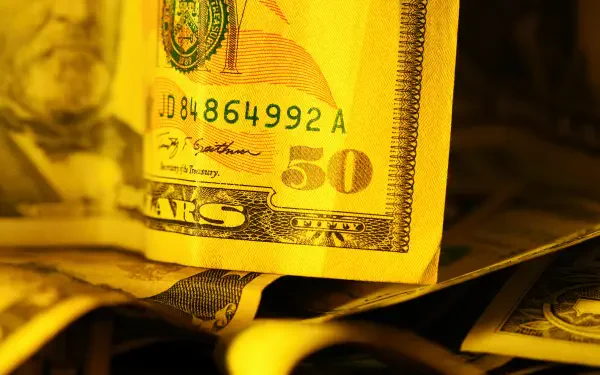 HD PC desktop wallpaper: close-up of American currency — a golden-toned fifty-dollar banknote atop stacked dollar bills (money, banknote).