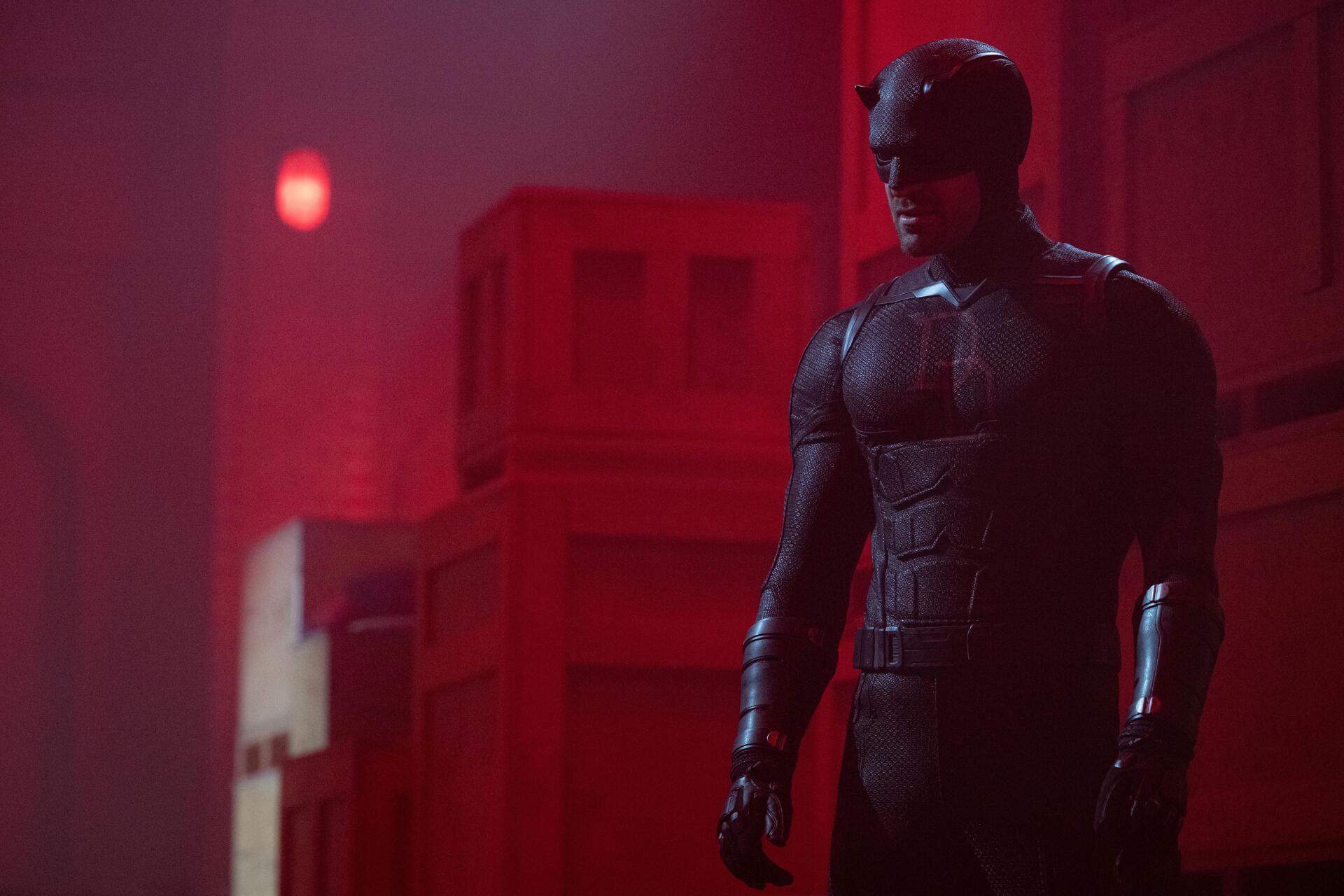 Daredevil from Daredevil: Born Again standing in a red-lit hallway in his suit — 8K Ultra HD TV show PC desktop wallpaper/background.