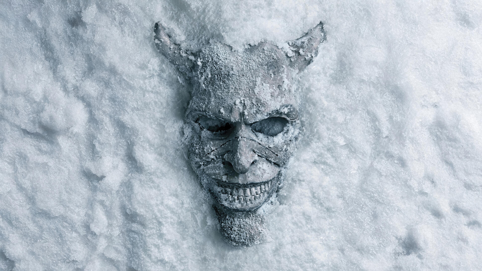 The Black Phone 2 8K Ultra HD PC desktop wallpaper and background: eerie horned skull mask half-buried in snow, frosted grinning face with hollow eyes.
