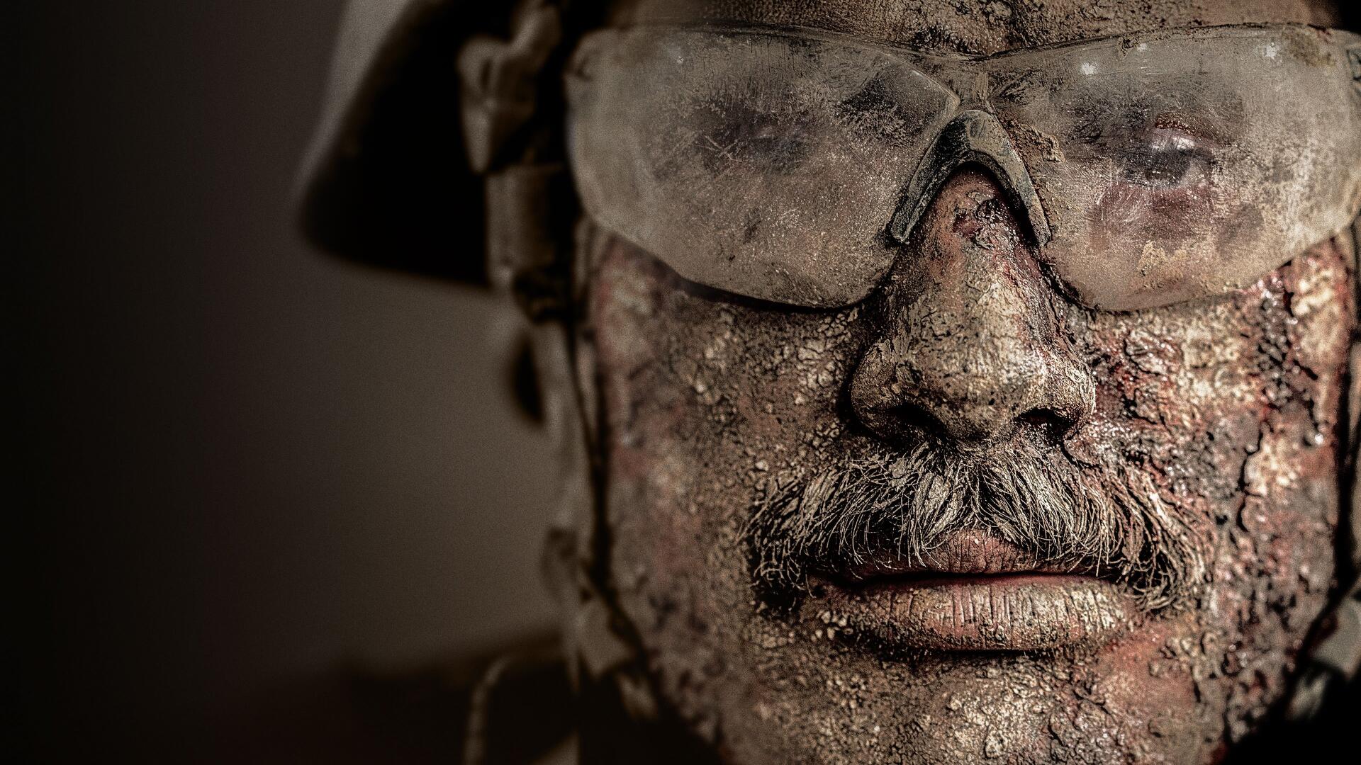 Warfare 4K Ultra HD PC desktop wallpaper: close-up of a battle-worn soldier's mud-caked face wearing goggles and helmet, gritty, high-detail texture.