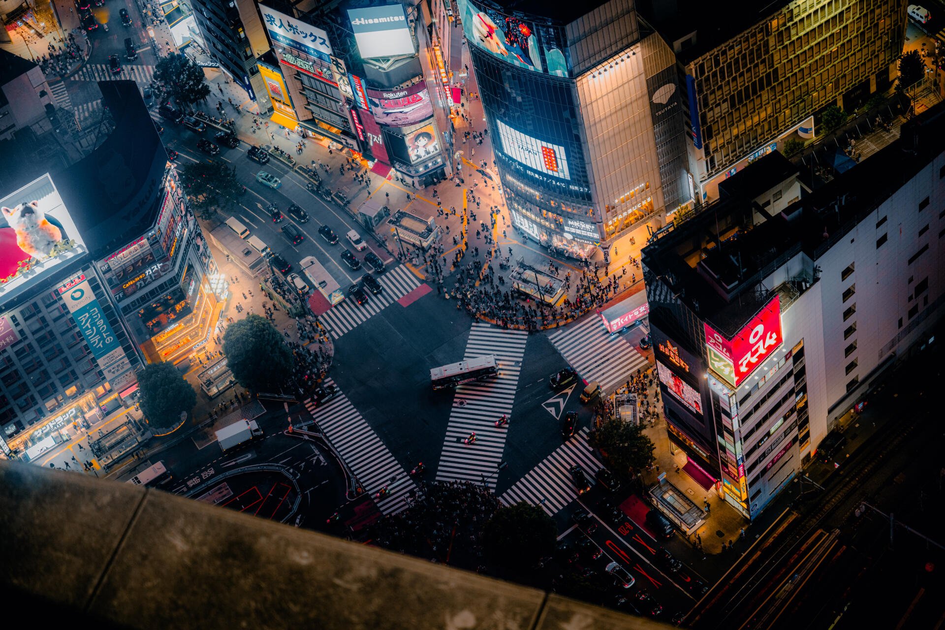 8K Ultra HD PC desktop wallpaper: aerial night cityscape of Shibuya Crossing in Tokyo, Japan — neon billboards, busy crosswalks and glowing streets.