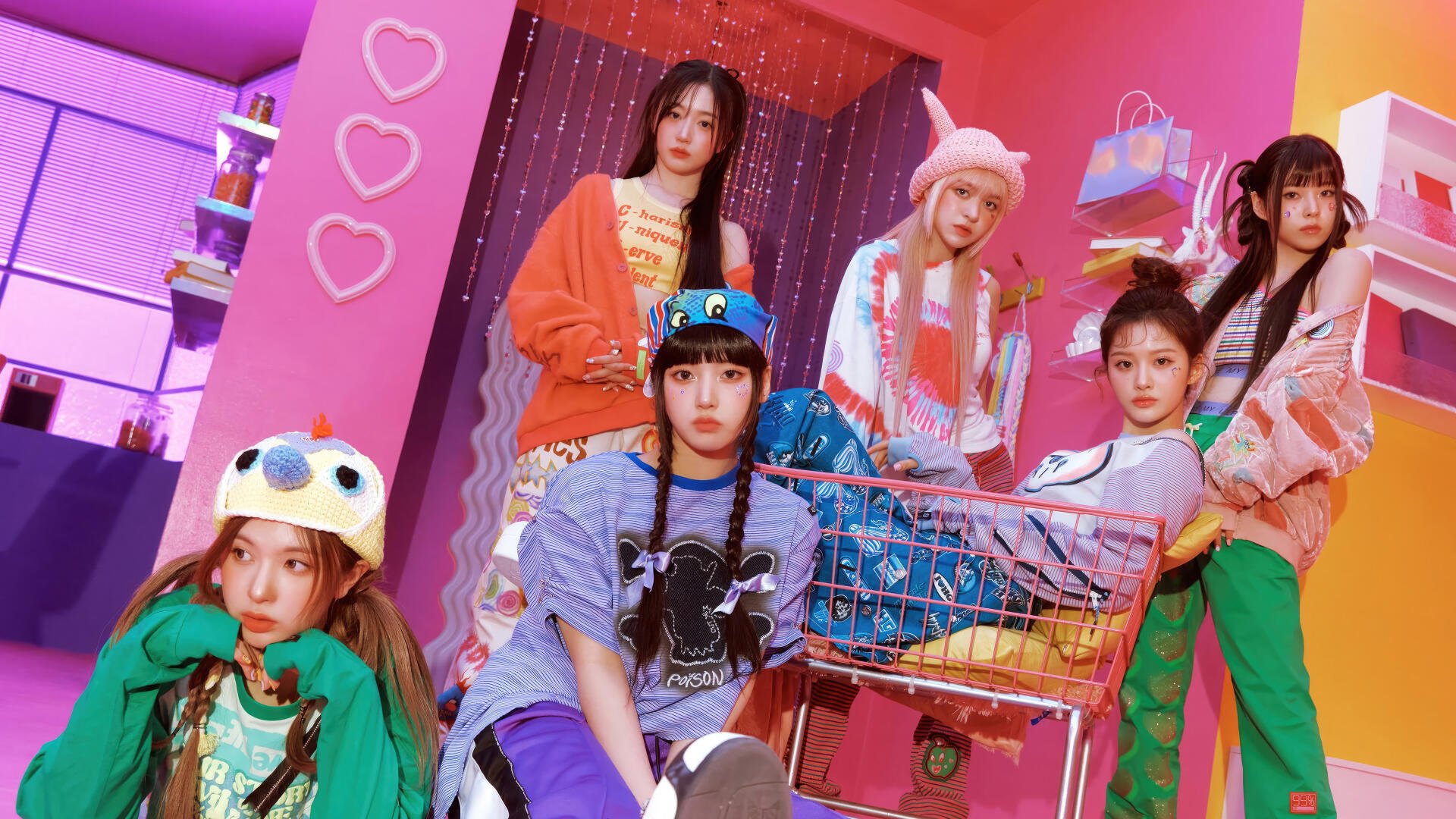 4K Ultra HD PC desktop wallpaper of a K-pop girl band in colorful fashion, posing with a shopping cart against a neon-pink backdrop, playful hats and layered street-style outfits.