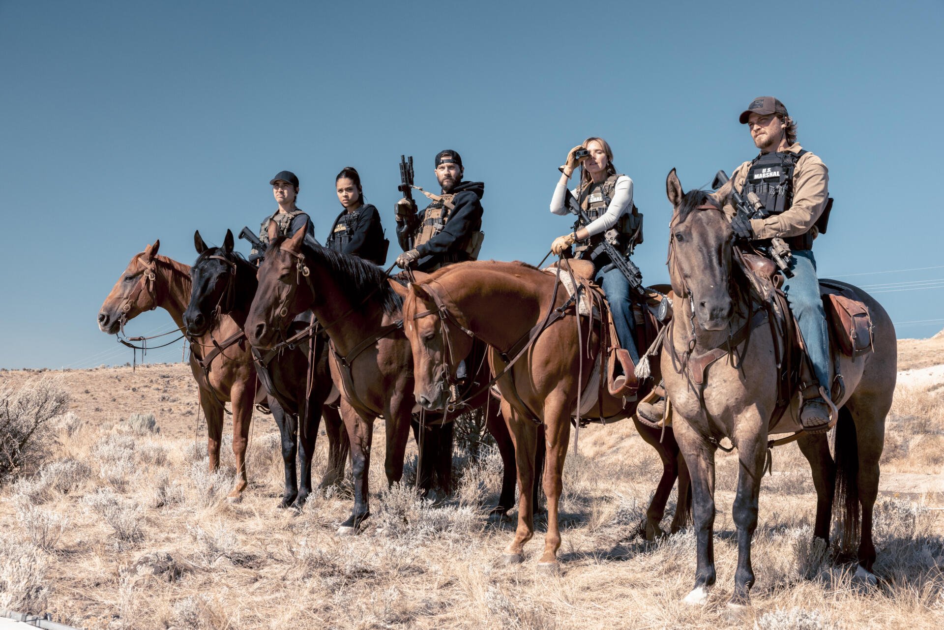 2K Quad HD PC desktop wallpaper: TV show marshals and military on horseback in a desert, five mounted riders in tactical gear under a clear blue sky.
