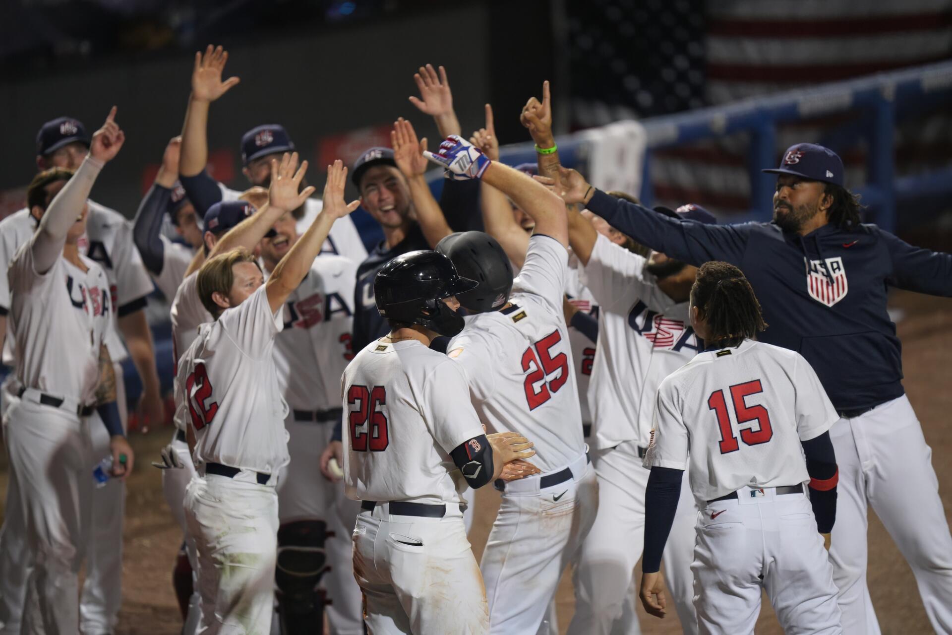 HD PC desktop wallpaper: USA Baseball team celebrating on the field, players in white uniforms and helmets high-fiving teammates during a game.