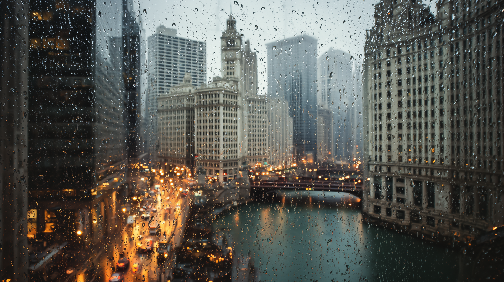 Rain-spattered Chicago cityscape on the Chicago River with the Wrigley Building and glowing streetlights — moody 2K Quad HD PC desktop wallpaper, Illinois.