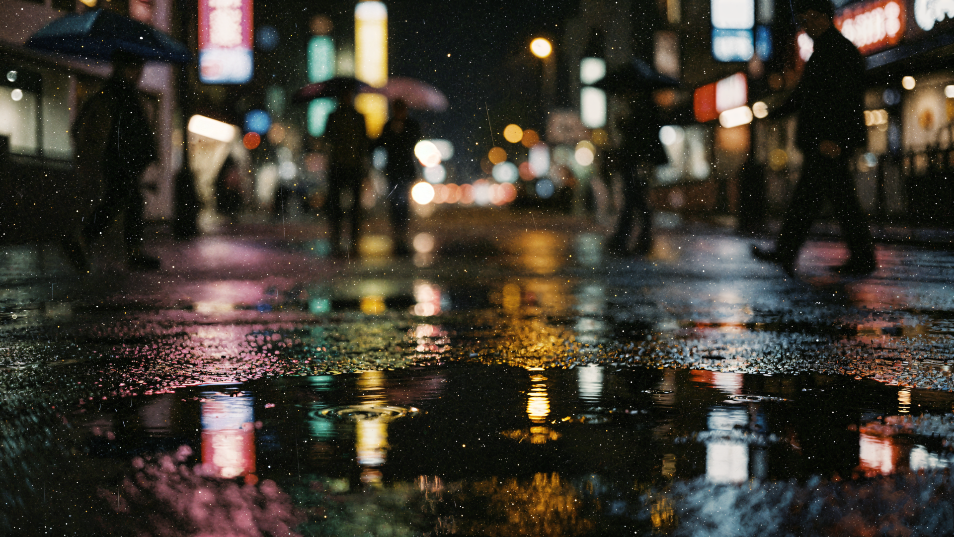 4K Ultra HD PC desktop wallpaper: rainy reflection on a night city street, umbrellas and neon lights blurred and shimmering in puddles.
