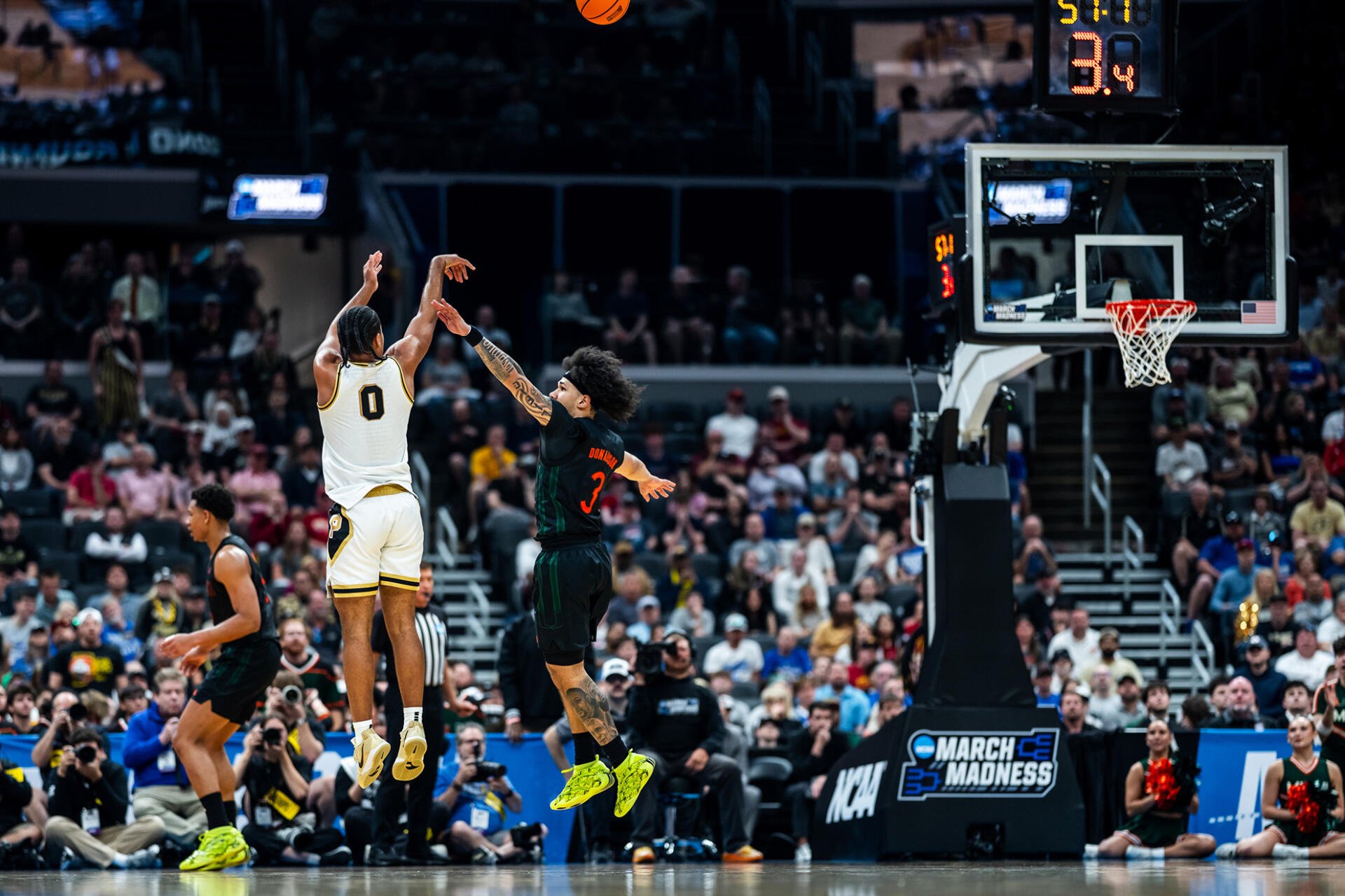 HD PC desktop wallpaper/background of NCAA action: Purdue Boilermakers player releasing a jump shot over defenders in a packed arena.