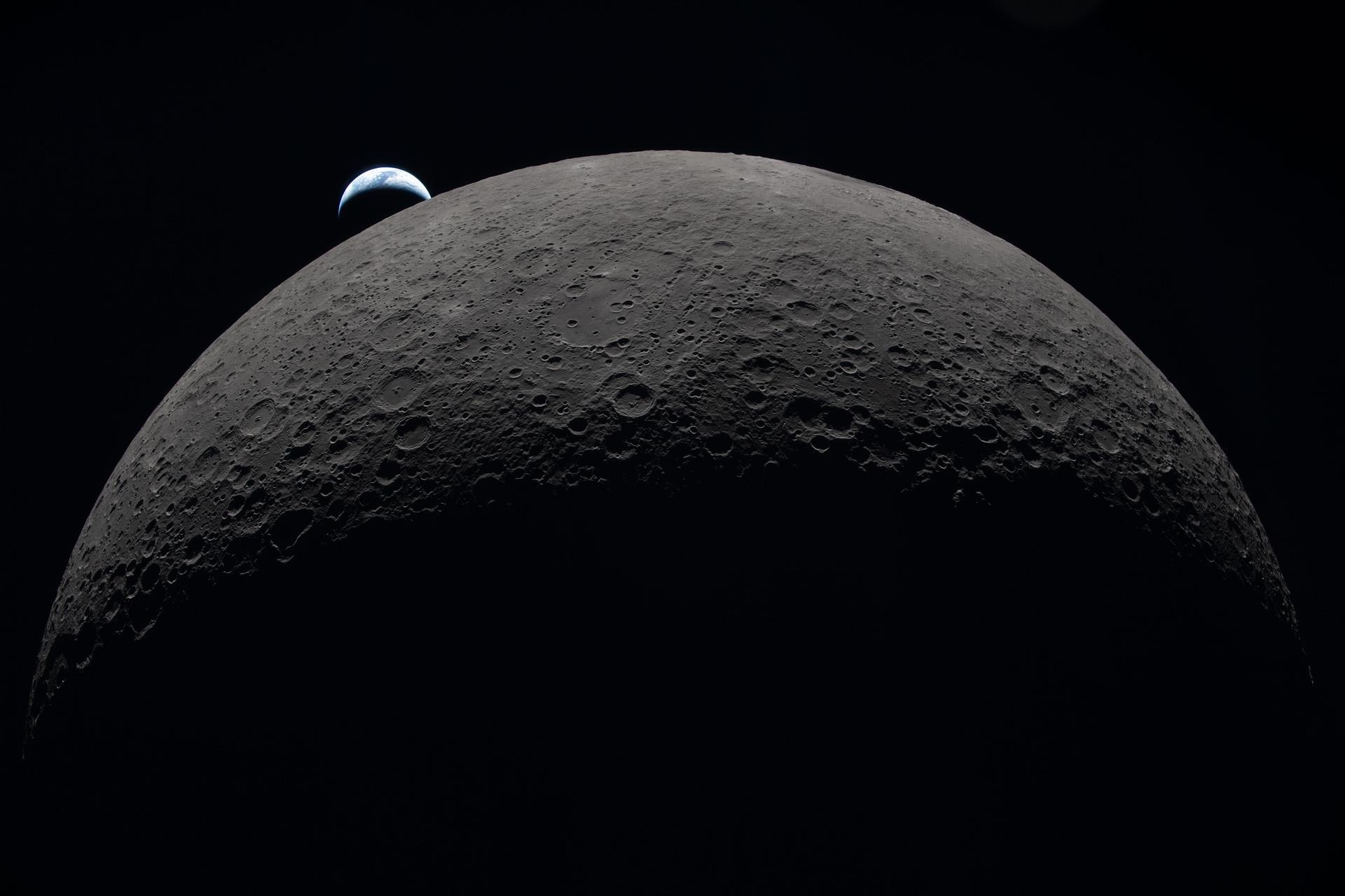 HD PC desktop wallpaper: NASA Artemis II view of the Moon's cratered limb in deep shadow with Earth rising above the horizon against the black void of space.