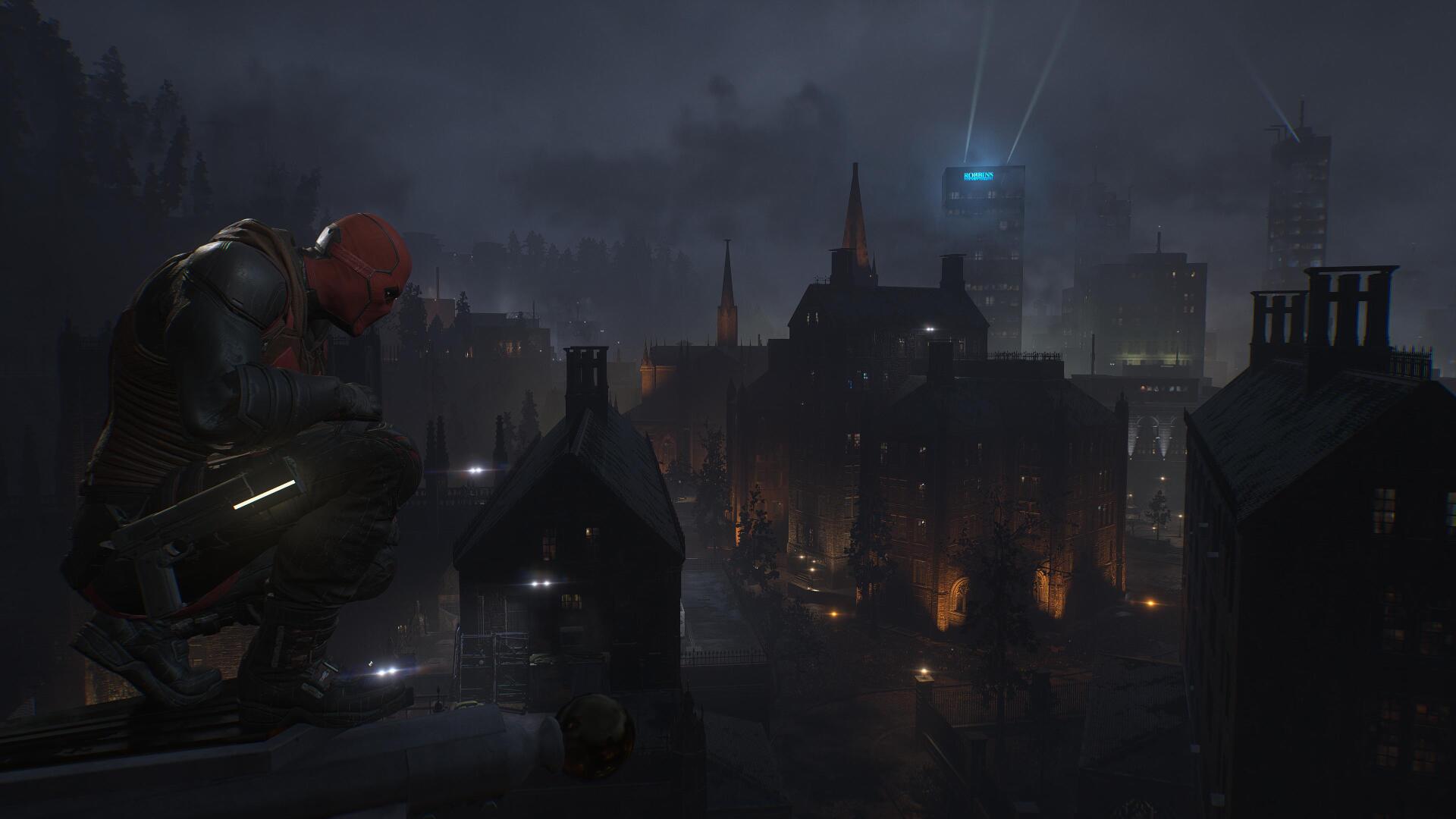 Red Hood from the Gotham Knights video game crouches on a rain‑slick rooftop overlooking a foggy, neon‑lit Gotham skyline, 4K Ultra HD PC desktop wallpaper and background.