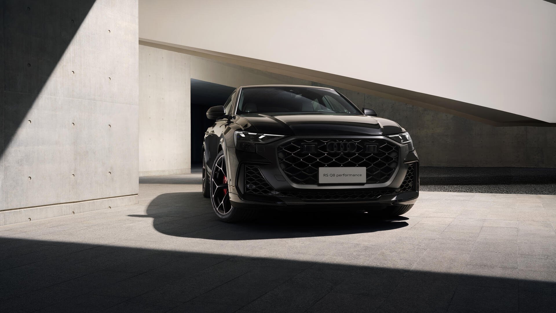 Black Audi RS Q8 SUV in dramatic shadowed modern architectural garage, presented as a 5K Ultra HD PC desktop wallpaper.