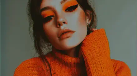 Close-up portrait of a woman in an orange sweater with bold orange eye makeup, orange aesthetic — 4K Ultra HD PC desktop wallpaper and background.