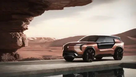 Mitsubishi Elevance concept SUV parked by desert rock formation, rendered in 8K Ultra HD as a PC desktop wallpaper/background.