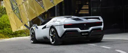 White Ferrari SC40 vehicle shown rear three-quarter, parked by modern architecture - 2K Quad HD PC desktop wallpaper/background.