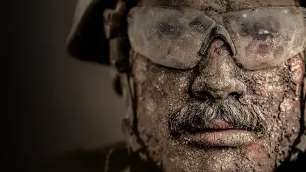 Warfare 4K Ultra HD PC desktop wallpaper: close-up of a battle-worn soldier's mud-caked face wearing goggles and helmet, gritty, high-detail texture.