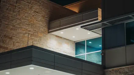 5K Ultra HD photography of modern architecture: illuminated window and recessed ceiling lights on stone and metal facades — PC desktop wallpaper background.