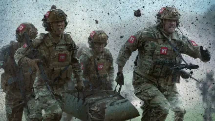 War Machine (2026) 4K Ultra HD PC desktop wallpaper: four battle-worn soldiers sprinting through debris, carrying a stretcher amid explosions and flying rubble.