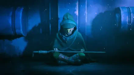 Star Wars: Maul – Shadow Lord TV show 2K Quad HD desktop wallpaper: hooded figure kneels in a blue-lit industrial room, gripping a long staff amid shadowy pipes and mist.