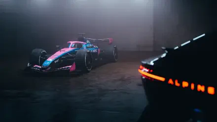4K Ultra HD desktop wallpaper: Alpine F1 Team race car in blue and pink livery parked in a dim garage, with a glowing ALPINE taillight in the foreground.