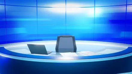Tomodachi Life: Living the Dream HD PC desktop wallpaper — a futuristic blue broadcast desk with an empty anchor chair, laptop and papers against a glowing tiled backdrop.