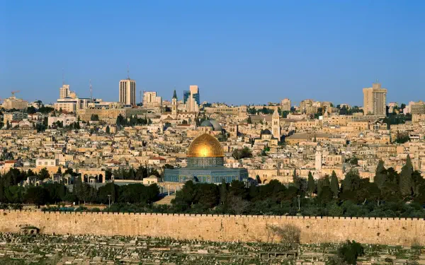 HD PC desktop wallpaper background: panoramic Jerusalem cityscape with the golden Dome of the Rock rising above stone buildings beneath a clear blue sky.