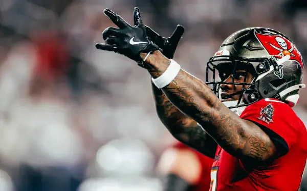 HD PC desktop wallpaper: NFL player in a Tampa Bay Buccaneers uniform reaching up with both hands in celebration on the field.