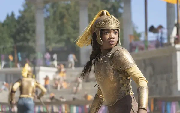 HD PC desktop wallpaper from the TV show Percy Jackson and the Olympians: a young warrior in gold armor and helmet stands alert in a sunlit stadium crowd.