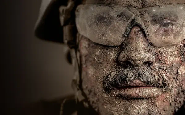 Warfare 4K Ultra HD PC desktop wallpaper: close-up of a battle-worn soldier's mud-caked face wearing goggles and helmet, gritty, high-detail texture.