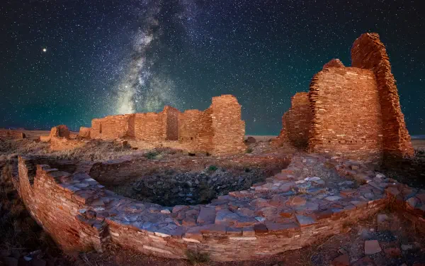 5K Ultra HD PC desktop astrophotography wallpaper of a ruined stone castle beneath a vivid Milky Way and star-filled night sky.