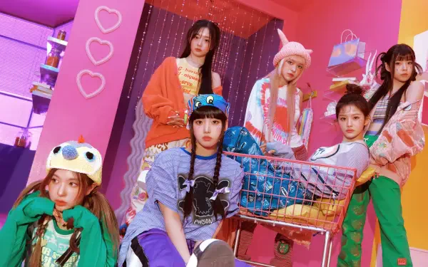 4K Ultra HD PC desktop wallpaper of a K-pop girl band in colorful fashion, posing with a shopping cart against a neon-pink backdrop, playful hats and layered street-style outfits.