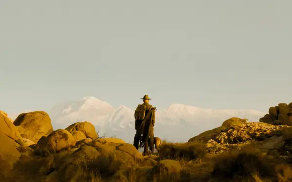 Fallout TV show 4K Ultra HD PC wallpaper: a lone cowboy and dog stand on a rocky outcrop overlooking distant snowy peaks under a vast yellow-tinted sky.