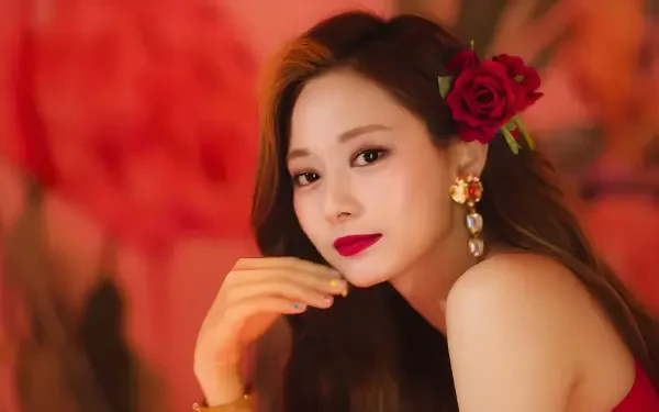HD desktop wallpaper of a k-pop idol with summer vibes — red rose tucked behind her ear, glamorous earrings and a warm, blurred floral backdrop.