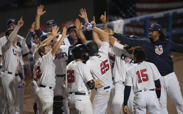 HD PC desktop wallpaper: USA Baseball team celebrating on the field, players in white uniforms and helmets high-fiving teammates during a game.