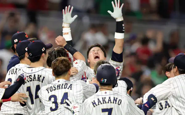 World Baseball Classic HD PC desktop wallpaper: pinstriped baseball team celebrating on field, players raising arms and cheering before a blurred stadium crowd.