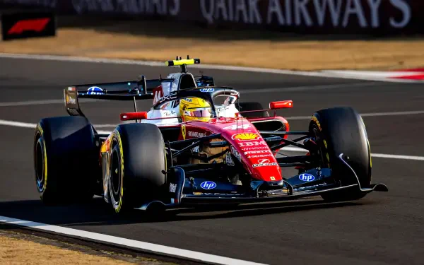 2K Quad HD desktop wallpaper of a Ferrari F1 Scuderia Ferrari racing car on track, helmeted driver (driver identity not disclosed).