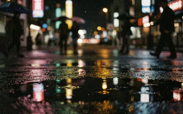4K Ultra HD PC desktop wallpaper: rainy reflection on a night city street, umbrellas and neon lights blurred and shimmering in puddles.