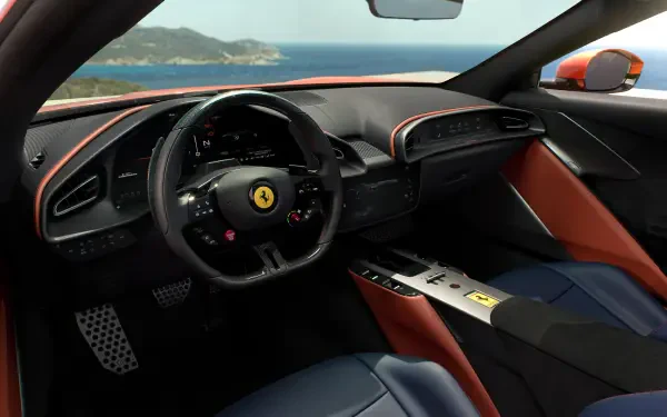 2K Quad HD desktop wallpaper of a Ferrari Amalfi Spider car interior: black leather steering wheel with prancing horse emblem, red-accented dash, blue seats and ocean view through windshield.