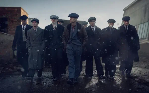 Peaky Blinders: The Immortal Man movie wallpaper — gang of flat-capped gangsters in overcoats stride through a rain-slick alley at dusk. 4K Ultra HD PC desktop background.