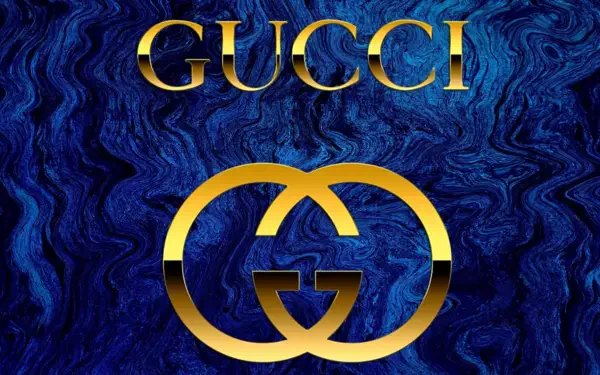 HD PC desktop wallpaper featuring Gucci brand logo: gold interlocking Gs and GUCCI wordmark on a deep blue marbled man-made background.