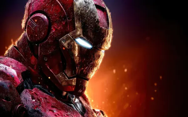 Digital art 5K Ultra HD wallpaper: close-up of Iron Man's battle-scarred mask with glowing eyes and scorched red-gold armor — Marvel Comics superhero on a PC desktop background.