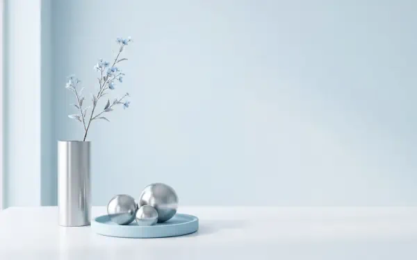 Clean minimalist 5K Ultra HD PC desktop wallpaper and background: pale blue wall, white surface, slender silver vase with delicate branches and three reflective spheres on a blue tray.