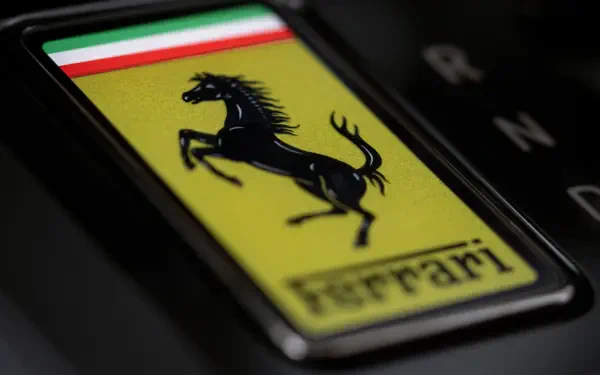 Close-up of Ferrari prancing horse badge with Italian tricolor and Ferrari Luce text — 4K Ultra HD PC desktop wallpaper/background featuring the vehicle emblem.