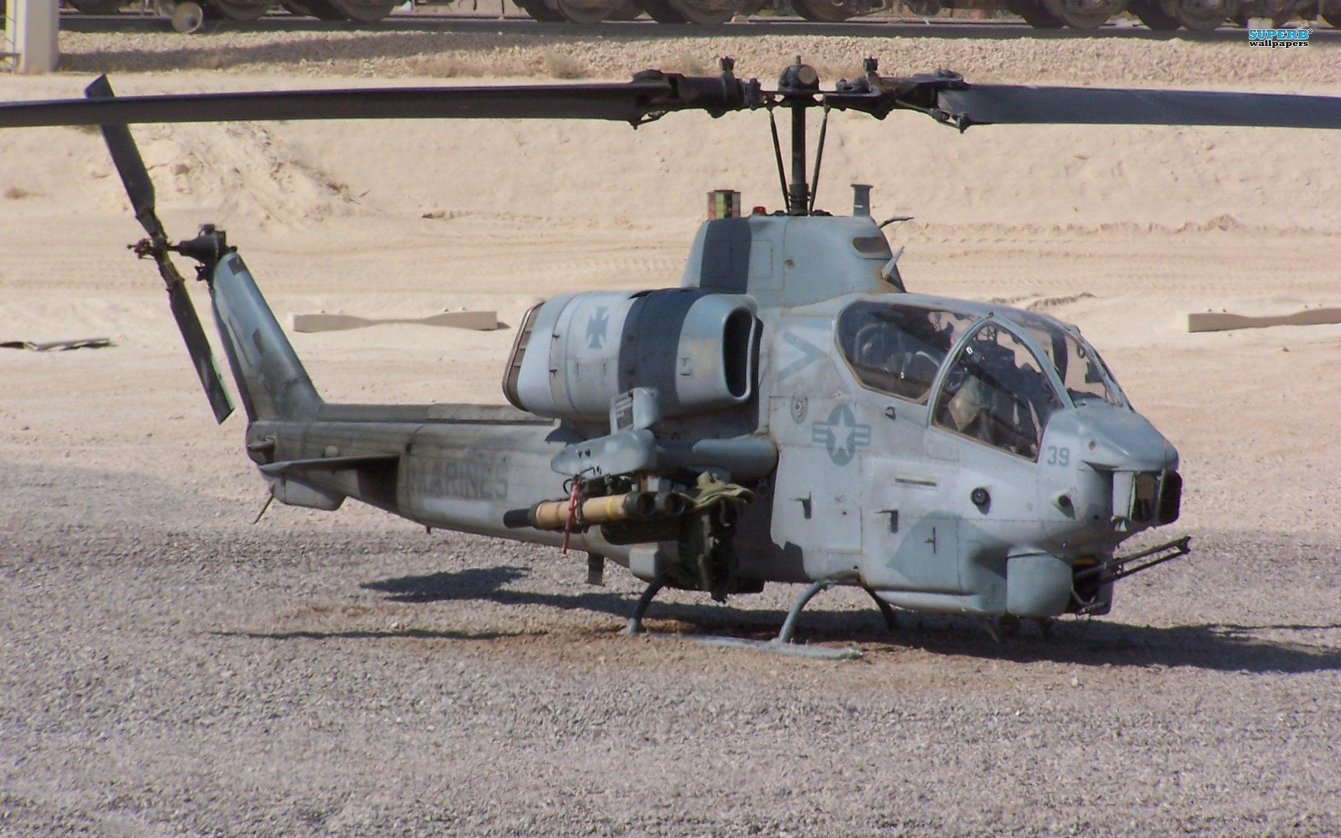 AH-1 Cobra Gunship flying over a military landscape