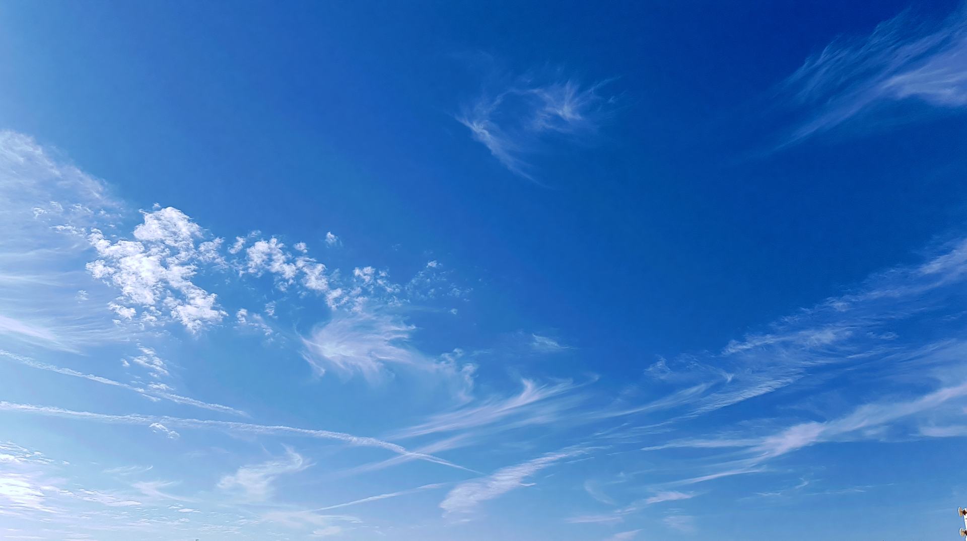 2K Quad HD PC desktop wallpaper: vivid blue sky with wispy white clouds and faint contrails.