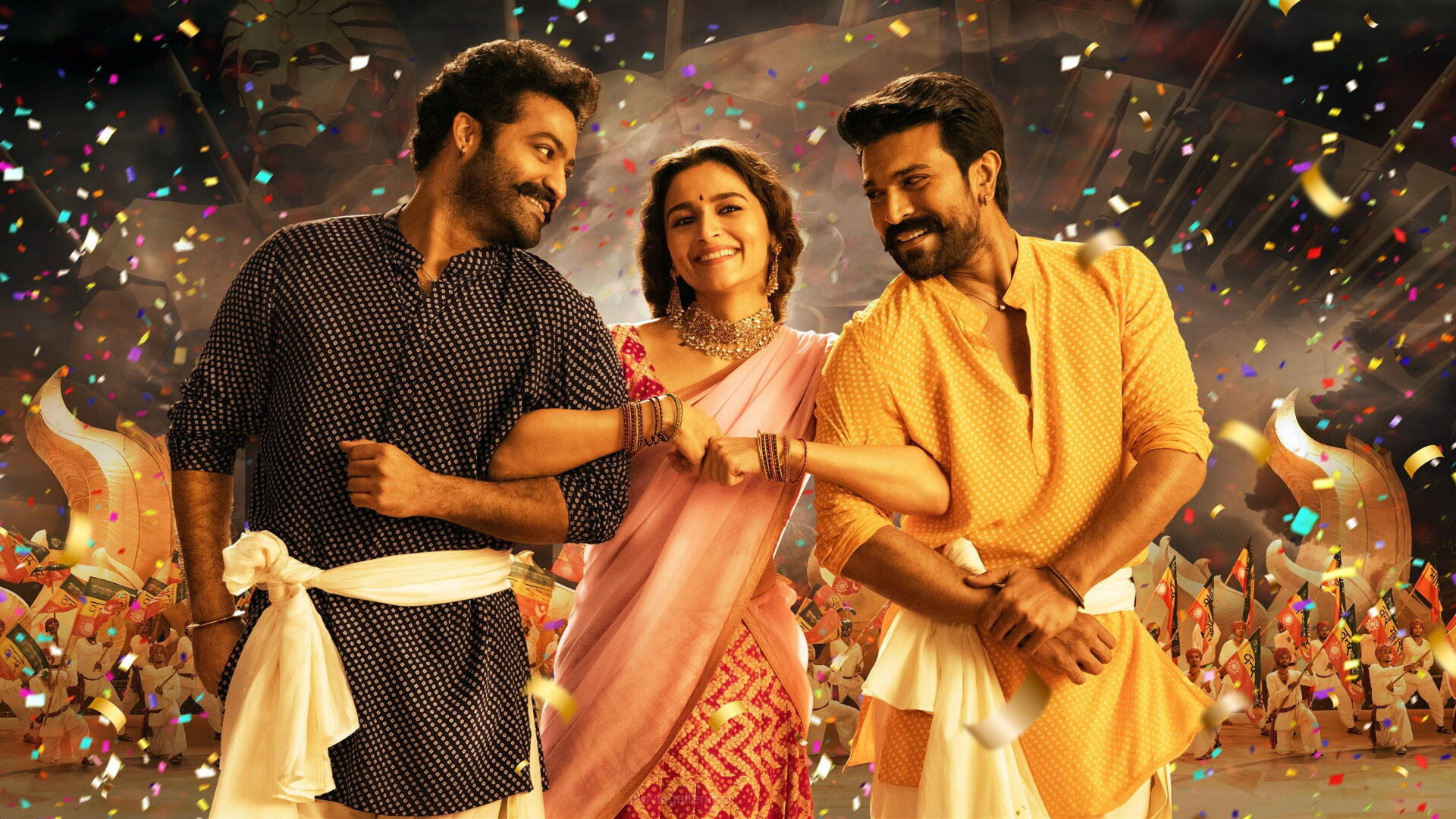 RRR 2K Quad HD PC desktop wallpaper and background: three smiling figures in traditional dress dancing amid confetti and warm festival lights.