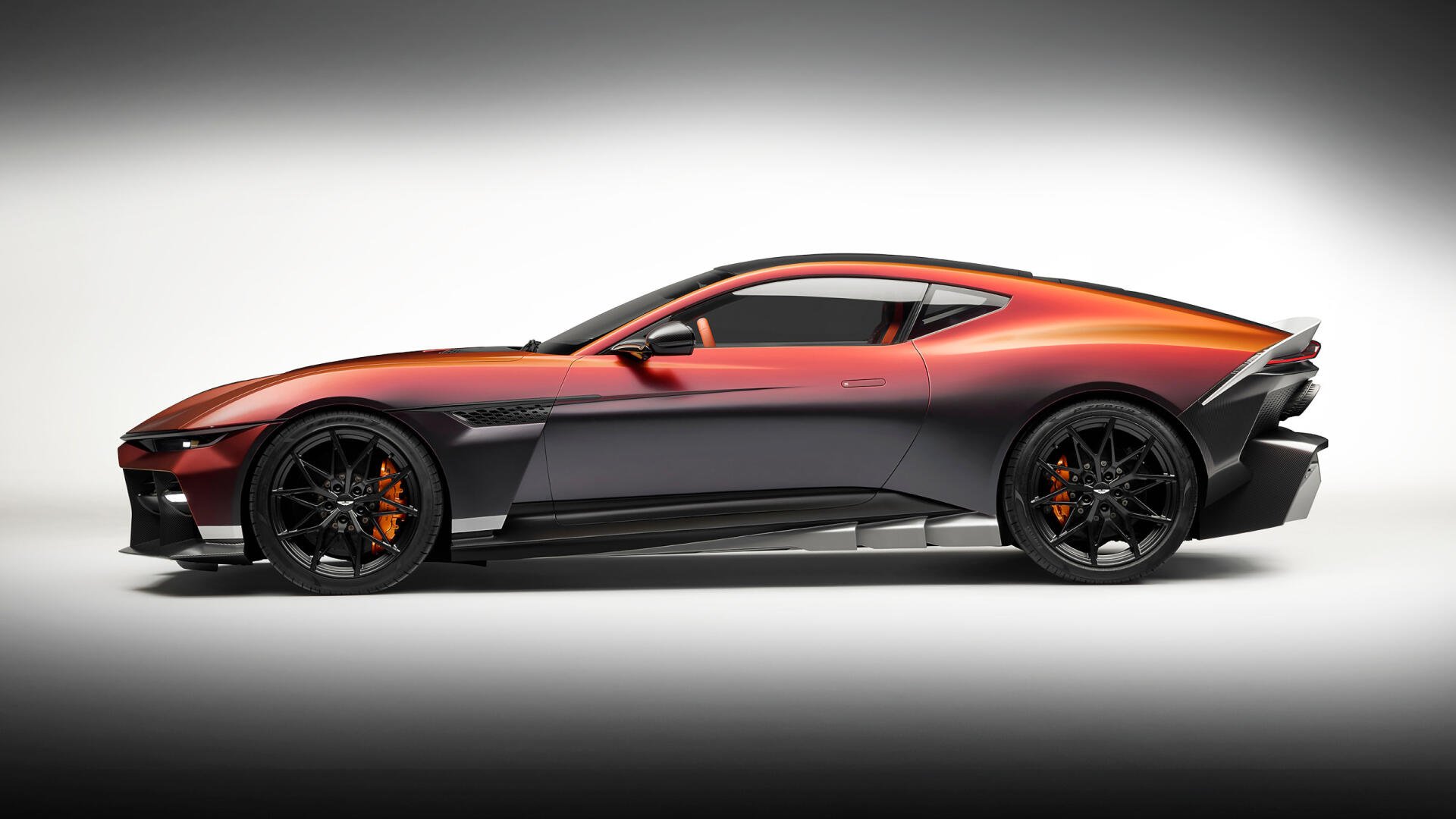 2K Quad HD desktop wallpaper: side view of an orange-gray Aston Martin Valen coupé sports car on a soft white vignette backdrop.
