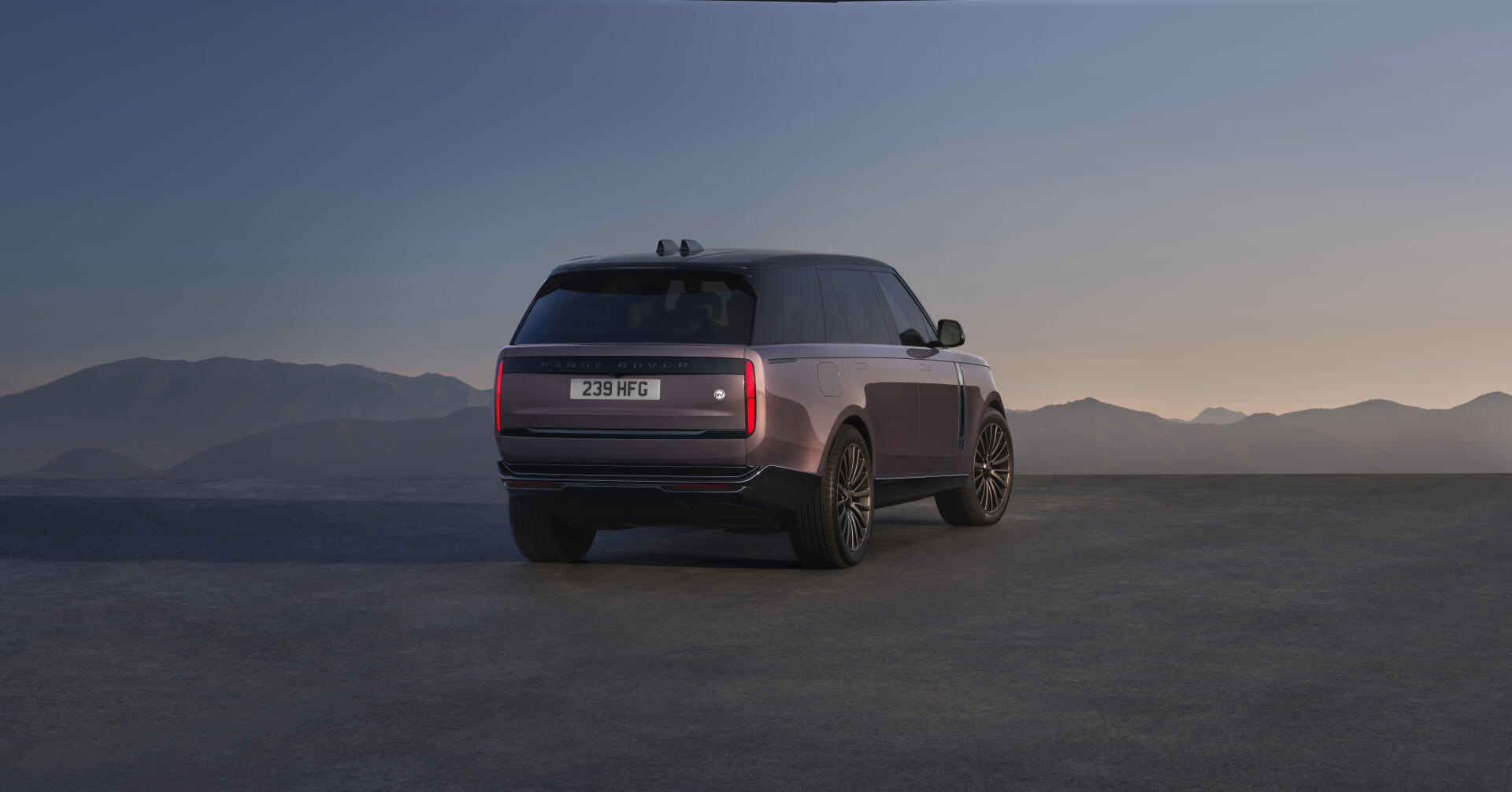 Rear three-quarter view of a Range Rover Electric SUV on a flat plain at dusk — 8K Ultra HD PC desktop wallpaper/background of the electric vehicle.