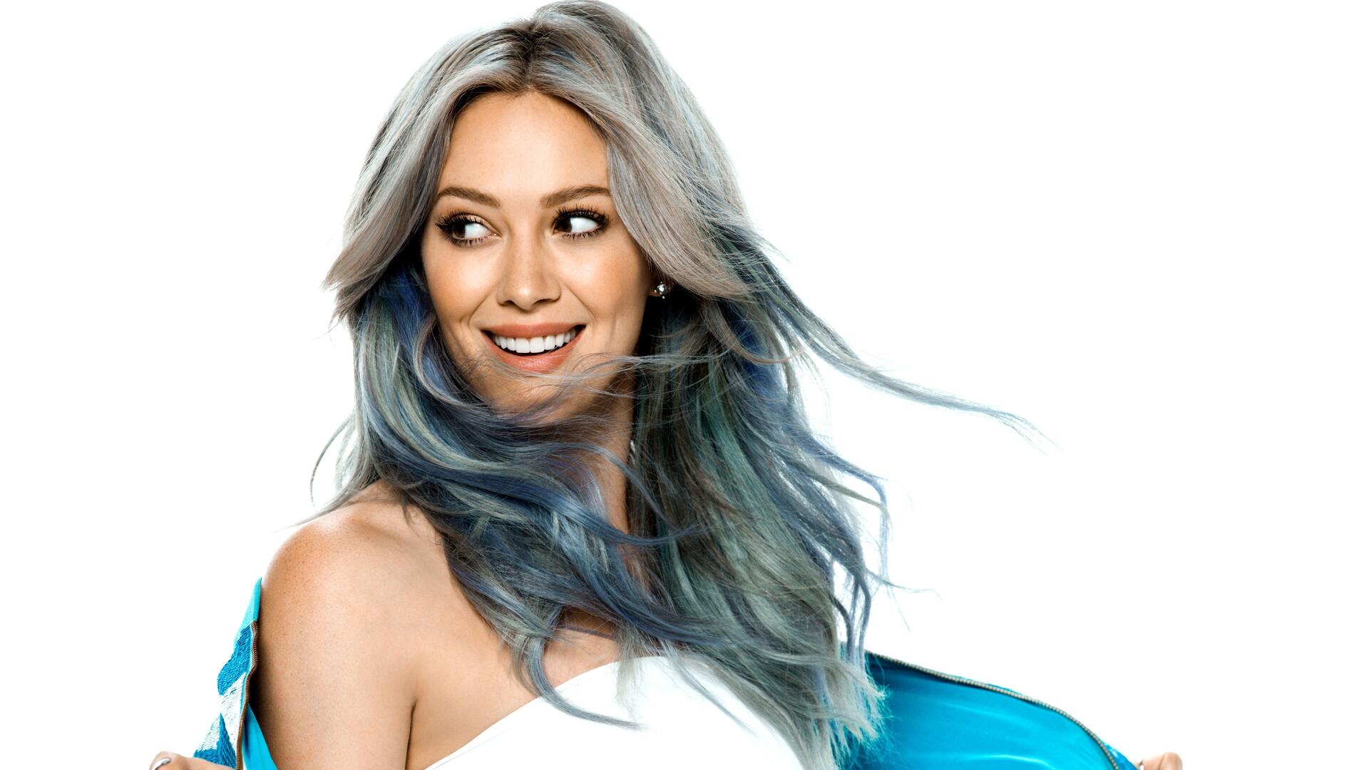 Smiling female celebrity with silver-blue hair and teal jacket on a white background — 4K Ultra HD PC desktop wallpaper/background.