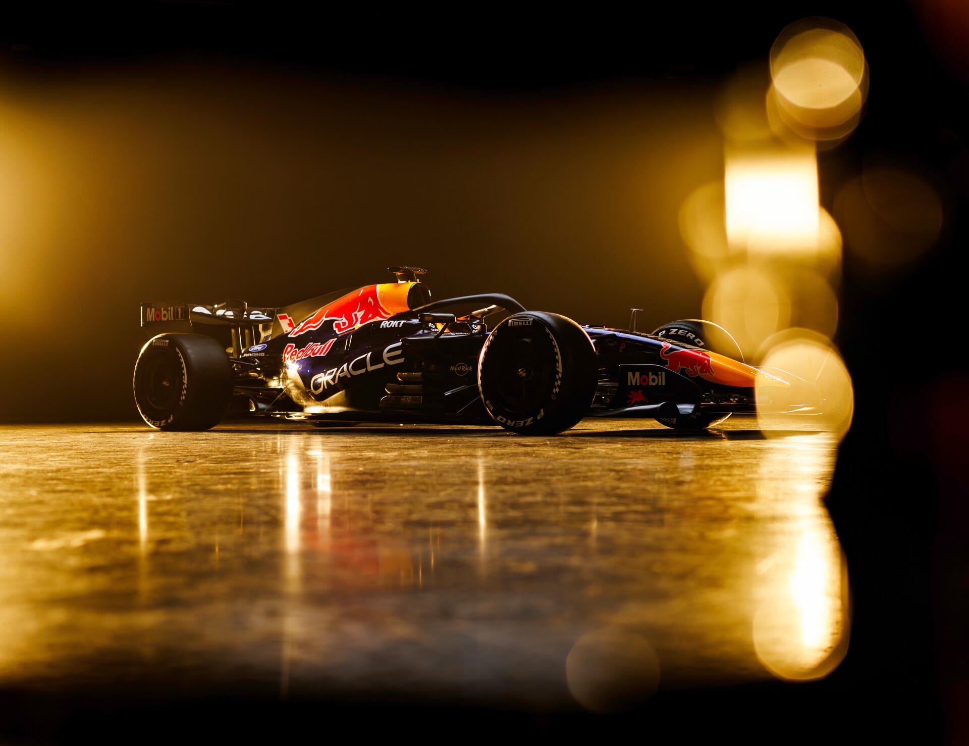 Red Bull Racing RB22 F1 race car speeding through a golden-lit track, 4K Ultra HD PC desktop wallpaper and background.