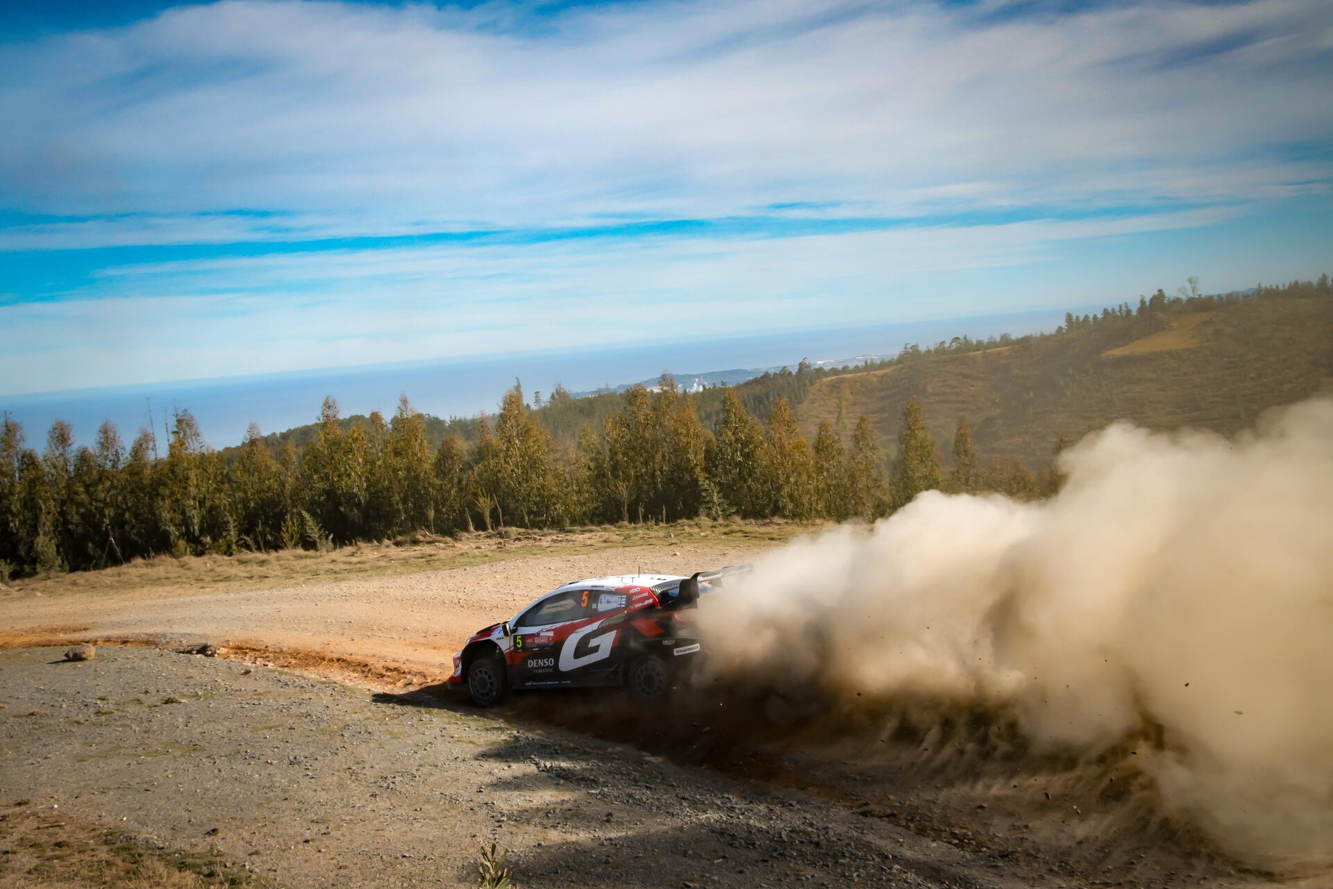 Toyota Gazoo Racing GR Yaris Rally1 powers through a dusty WRC rally stage in this 5K Ultra HD desktop wallpaper.