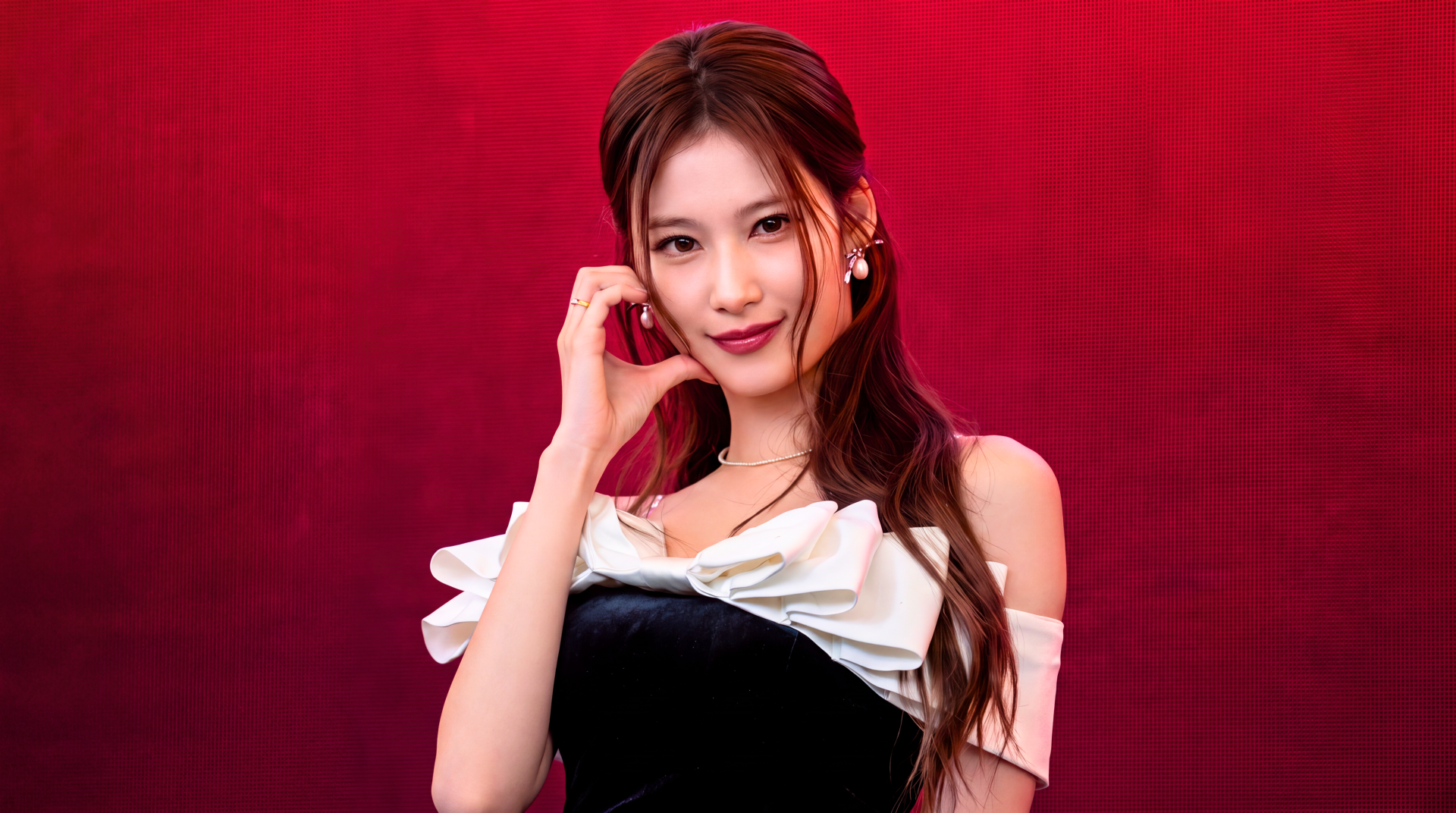 TWICE and MiSaMo’s Sana, Japanese model and K-pop singer, poses against a red backdrop in a 5K Ultra HD desktop wallpaper.